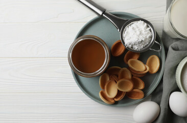 Ingredients for delicious walnut shaped cookies with condensed milk on white wooden table, flat lay. Space for text