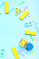 Fototapeta na wymiar Frame made of baby toys and confetti on blue background. Children's Day celebration