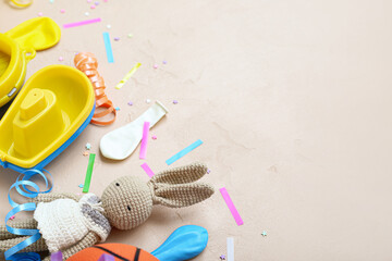 Baby toys with confetti on beige background, closeup. Children's Day celebration