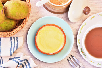 Lemon tart on a plate with hot tea