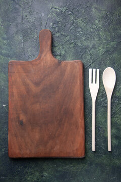 top view plastic utencils fork and spoon on wooden cutting board on a dark background kitchen cutlery food photo knife dinner plastic