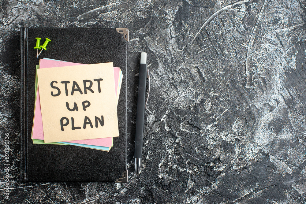Wall mural top view start up plan note on sticker with copybook on gray background lesson student note notepad 