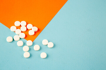 top view white pills on orange-blue background lab disease drug covid- health pandemic virus vaccine