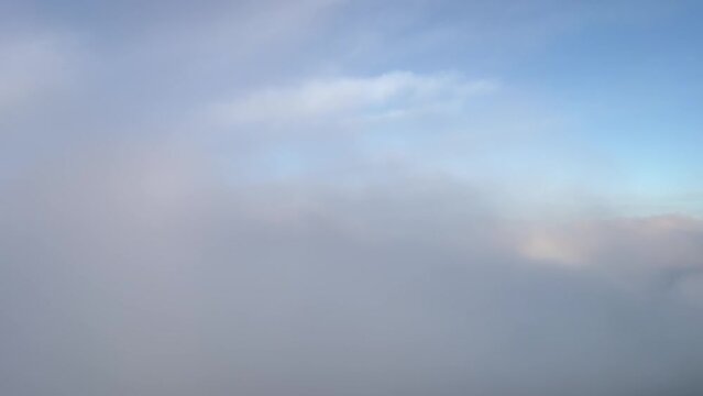 A pilot&rsquo;s perspective: Airplane flying just above the clouds with the halo of the plane ahead. Daylight.
