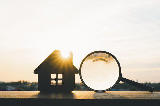 Magnifying glass for looking at house model, house selection, real estate concept.