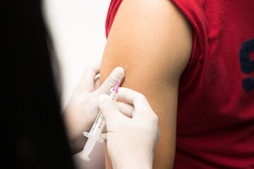Close up doctor's hand injecting for vaccination in the shoulder man patien on white background.Vaccine for protection covid-19 (Corona virus) infection.Vaccination for influenza treatment.