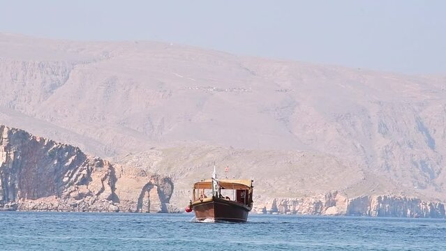 Traditional tour boat on water on cruise in persian gulf. Oman travel famous leisure activities