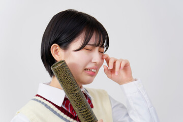 ワニ柄の筒を持って泣く女子高生　白背景