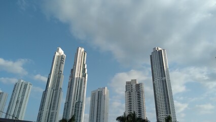 Fototapeta na wymiar background skyscraper buildings on blue sky with clouds