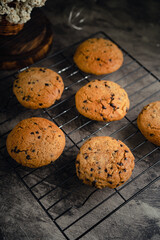 Homemade chocolate chip cookies on black baking cooling tray and abstract background