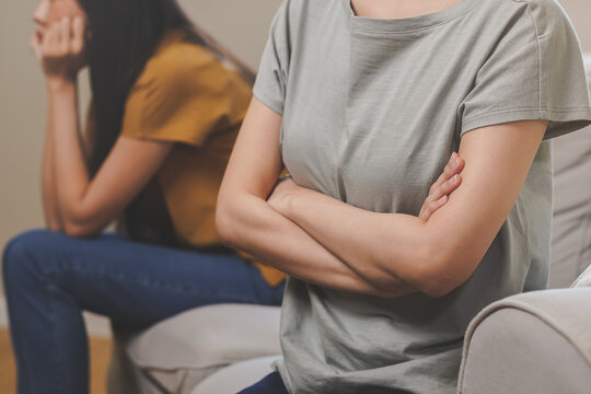 Unhappy lesbian, lgbt asian young two women, girl gay, couple love fight on sofa, relationship is in trouble. Different people are angry and use emotions at each other, expression of disappointmen.