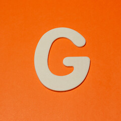Uppercase letter G - wood texture - Orange background