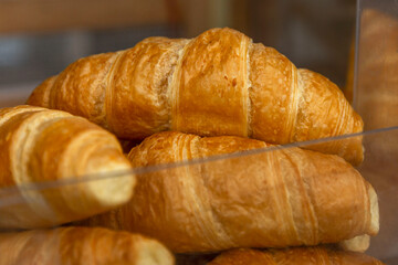 Fresh croissants on the counter. Traditional pastries for breakfast and coffee. Close-up.