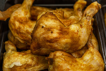 Appetizing fried grilled chicken legs on the counter. Traditional delicious fast food. Close-up.