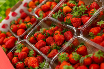 Fresh strawberries in containers on the counter. Health, vitamins and natural products. Side view. Close-up.