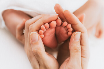 Obraz na płótnie Canvas Mother's hands holding baby feet