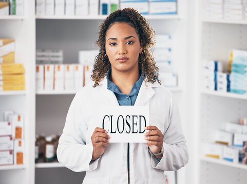 Portrait, woman and closed sign of store, pharmacy and shop in recession, bankruptcy and economy. Serious female pharmacist advertising retail closing with poster, board and announcement in drugstore
