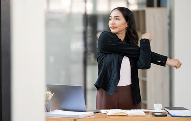 Young attractive Businesswoman Stretching Her Arms At Desk