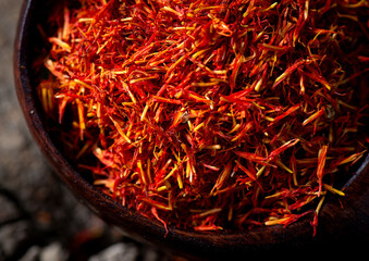 Fototapeta premium Saffron in bowl and saffron tea,wooden background, closeup