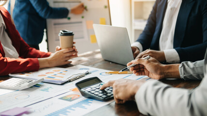 Businessman and team analyzing financial statement Finance task. with smart phone and laptop and ...