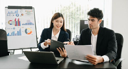Female discussing new project with male colleague. Mature woman talking with young man in office.