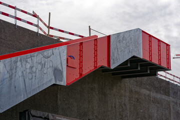Highway construction site at City of Z&uuml;rich with orange gray metal stairway up to roof of concrete cover of motorway on a cloudy spring day. Photo taken March 28th, 2023, Zurich, Switzerland.