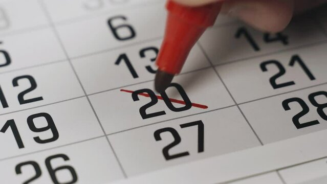 The twentieth in the calendar is boldly crossed out with a red marker as an important event completed. Close-up.