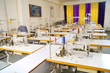 Interior of garment factory making atelier with several sewing machines. Tailoring industry.