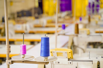 Interior of garment factory making atelier with several sewing machines. Tailoring industry.