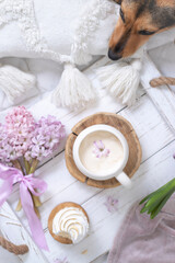 A cup of warm aromatic coffee on a tray and hyacinth flowers
