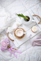 A cup of warm aromatic coffee on a tray and hyacinth flowers