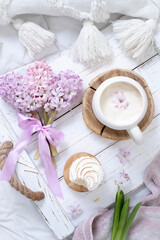 A cup of warm aromatic coffee on a tray and hyacinth flowers