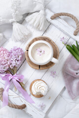 Obraz na płótnie Canvas A cup of warm aromatic coffee on a tray and hyacinth flowers