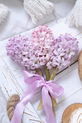 A bouquet of hyacinths tied with a pink ribbon on a white tray