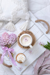 Fototapeta na wymiar A cup of warm aromatic coffee on a tray and hyacinth flowers
