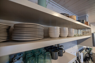 bowls, plates and mugs on open shelves in a kitchen