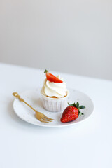 dessert Cream cupcake with fresh red strawberries on a plate