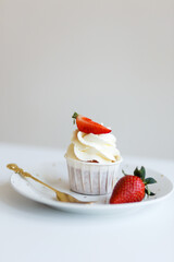 dessert Cream cupcake with fresh red strawberries on a plate