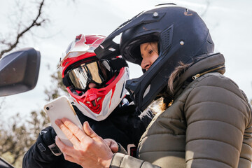 two people looking at the route on the cell phone while riding a quad