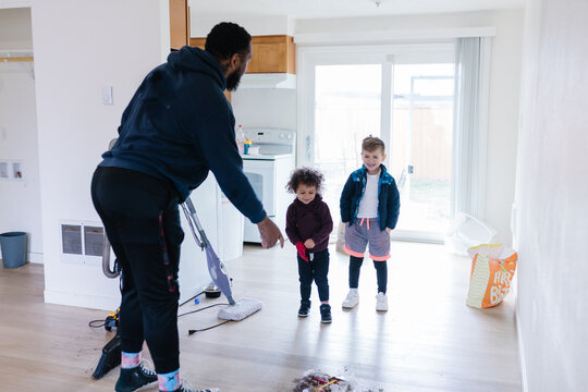 Dad showing and teaching kids how to clean and sweep