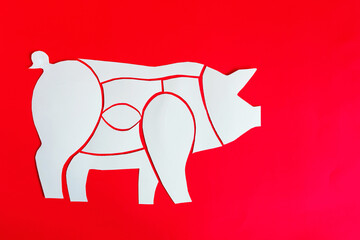 Scheme of cutting pork carcass from cardboard on a red background
