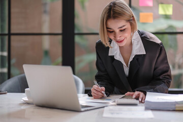 Fototapeta premium Business woman using calculator for do math finance on wooden desk in office and business working background, tax, accounting, statistics and analytic research concept..