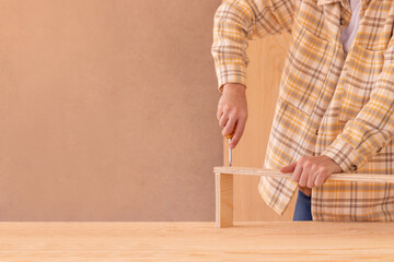 Workman with screwdriver making furniture. Crop faceless male carpenter screwing bolt with screwdriver into wooden plank