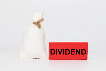 A picture of money bag with dividend at wooden block