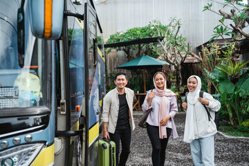 happy asian muslim passengers lined up in line to get on the bus
