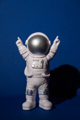 Plastic toy astronaut on colorful blue background Copy space. Concept of out of earth travel,...