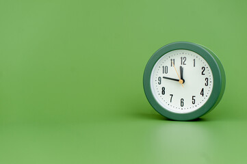 Fototapeta na wymiar alarm clock on green background time concept working with time precious time