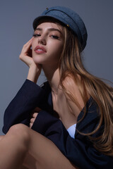 Seductive woman face. Sensual young woman posing in fashion cap hat. Beautiful sexy model. Beauty...