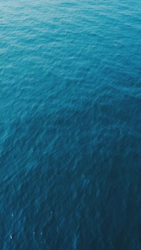 Aerial top down view of sea surface with deep blue water, moving forward