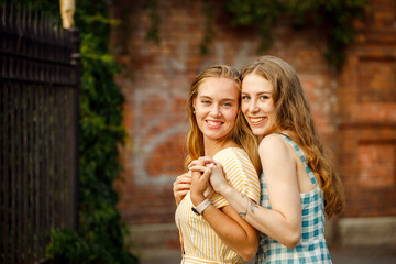 Fototapeta premium Lifestyle, people and friendship concept - two caucasian female friends expressing positive emotions to camera.